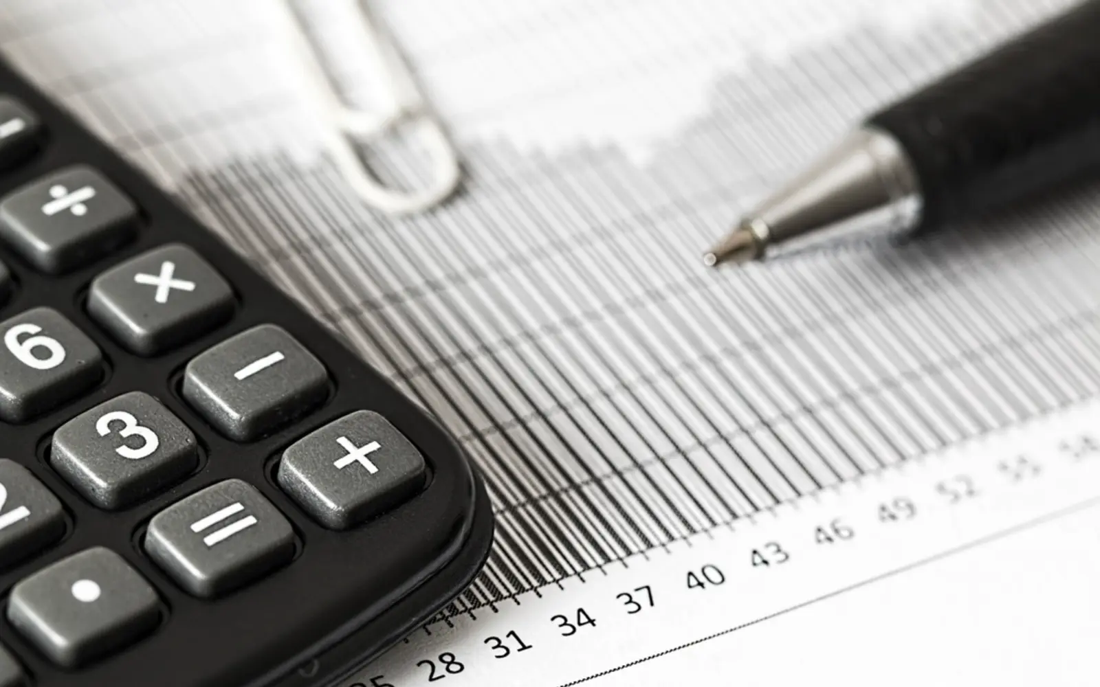A calculator and a pen on a financial chart